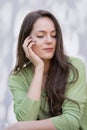 Portrait of an attractive brunette haired woman relaxing at white background outside Royalty Free Stock Photo