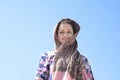 Portrait of a young woman with scarf in front of blue sky