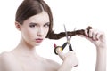 Portrait of beautiful young woman with scissors cutting her hair over white background Royalty Free Stock Photo