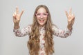 Portrait of beautiful young woman showing peace sign and toothy Royalty Free Stock Photo