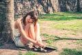 Portrait of a beautiful young woman sitting on the grass leaning against a tree in a public park. copy space. concept of joy and Royalty Free Stock Photo