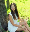 Portrait beautiful young woman sitting on a grass in summer park Royalty Free Stock Photo