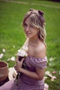 portrait of a beautiful young woman sitting on a green meadow in summer and holding a bouquet of pions. Royalty Free Stock Photo