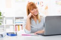 Portrait of beautiful young woman sitting her desk and looking at laptop Royalty Free Stock Photo