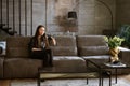 portrait of a beautiful young woman sitting on a sofa Royalty Free Stock Photo