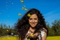 Portrait of a beautiful young woman smiling looking at camera with yellow flower petals in her hand Royalty Free Stock Photo