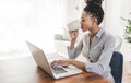 portrait of a beautiful young woman smiling and looking at laptop screen Royalty Free Stock Photo