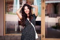 Portrait beautiful young woman smiling near shop window. Happy model dark long hair, pretty smile Royalty Free Stock Photo