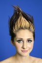 Portrait of a beautiful young woman with spiked hair over colored background Royalty Free Stock Photo