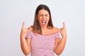 Portrait of beautiful young woman standing over isolated white background shouting with crazy expression doing rock symbol with Royalty Free Stock Photo