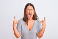 Portrait of beautiful young woman standing over isolated white background shouting with crazy expression doing rock symbol with Royalty Free Stock Photo