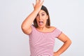 Portrait of beautiful young woman standing over isolated white background surprised with hand on head for mistake, remember error Royalty Free Stock Photo