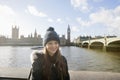 Portrait of beautiful young woman standing by river Thames, London, UK