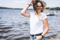 Portrait of a beautiful young woman in stylish glasses. Girl in white tshirt posing on the background of the lake landscape Royalty Free Stock Photo