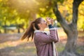 Portrait of beautiful young woman taking photos with vintage camera outdoors in the nature Royalty Free Stock Photo