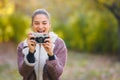 Portrait of beautiful young woman taking photos with vintage camera outdoors in the nature Royalty Free Stock Photo