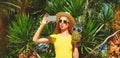 Portrait of beautiful young woman taking selfie with phone and pineapple in sunglasses and blowing her lips sends kiss in summer