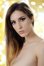 Portrait of a beautiful young woman topless in front blurry golden lights Royalty Free Stock Photo