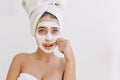 Portrait of beautiful young woman with towels after take bath make cosmetic mask and worries about her skin