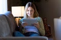 Beautiful young woman using her digital tablet at home. Royalty Free Stock Photo