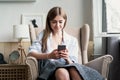 Portrait of beautiful young woman using her mobile phone at home Royalty Free Stock Photo