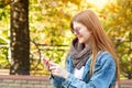 Portrait of beautiful young woman using her mobile phone in the park. Royalty Free Stock Photo