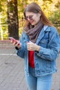 Portrait of beautiful young woman using her mobile phone in the park. Royalty Free Stock Photo