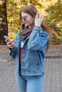 Portrait of beautiful young woman using her mobile phone in the park. Royalty Free Stock Photo