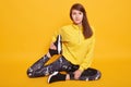 Portrait of beautiful young woman wearing black leggins and yellow sweater working out in studio. Fit sporty girl stretching with Royalty Free Stock Photo