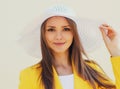 Portrait of beautiful young woman in a white straw hat and yellow suit Royalty Free Stock Photo