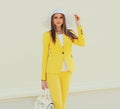 Portrait of beautiful young woman in a white straw hat and yellow suit Royalty Free Stock Photo