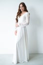 portrait of beautiful young woman in white wedding dress posing in studio.