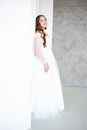 portrait of beautiful young woman in white wedding dress posing in studio.