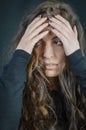 Portrait of a beautiful young woman who tries to hide her face with her hands and go unnoticed Royalty Free Stock Photo