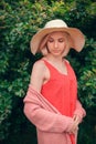 Portrait of beautiful young woman in wide beach hat, against background of summer green park Royalty Free Stock Photo