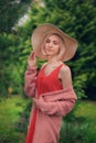 Portrait of beautiful young woman in wide beach hat, against background of summer green park Royalty Free Stock Photo