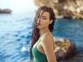 Portrait of beautiful young woman on wild rocky beach. Royalty Free Stock Photo