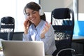 Portrait of beautiful young woman working on computer and chatting sitting in earphones Royalty Free Stock Photo