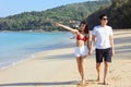 Portrait of beautiful young women and boyfriend asian, wearing rea bikini and stylish white sunglasses walking on the seashore