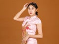 Portrait beauty action millennial Asian female model in pink cheongsam qipao traditional festival peacock and flowers pattern Royalty Free Stock Photo