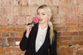 Portrait of beauty business woman with lolipop and santa hat wearing. Brick red background. Royalty Free Stock Photo