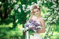 Portrait of beauty bride in white dress. The bride is holding a wedding bouquet of lilacs. Royalty Free Stock Photo