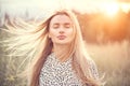 Portrait of beauty girl with fluttering white hair enjoying nature outdoors. Flying blonde hair on the wind. Beautiful young woman Royalty Free Stock Photo