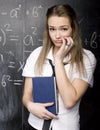 Portrait of beauty happy student with books near blackboard Royalty Free Stock Photo