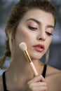 Portrait of beauty model with makeup and long eyelashes with cosmetic brush in hand Royalty Free Stock Photo