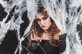 Portrait of Beauty Witch girl caught in a spider web. Fashion Art design. Beautiful Gothic model girl with