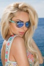 Portrait beauty stunning blonde model with perfect face wearing a sunglasses and elegant white bikini Royalty Free Stock Photo