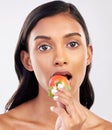 Portrait, beauty and a woman biting a strawberry in studio on a gray background for health, diet or nutrition. Face Royalty Free Stock Photo