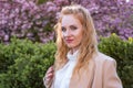 Portrait of beauty woman in blooming garden with cherry-tree. Young attractive woman with long curly hair in spring park Royalty Free Stock Photo