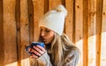 Portrait of beauty young woman blow to blue cup of tea in white cap Royalty Free Stock Photo